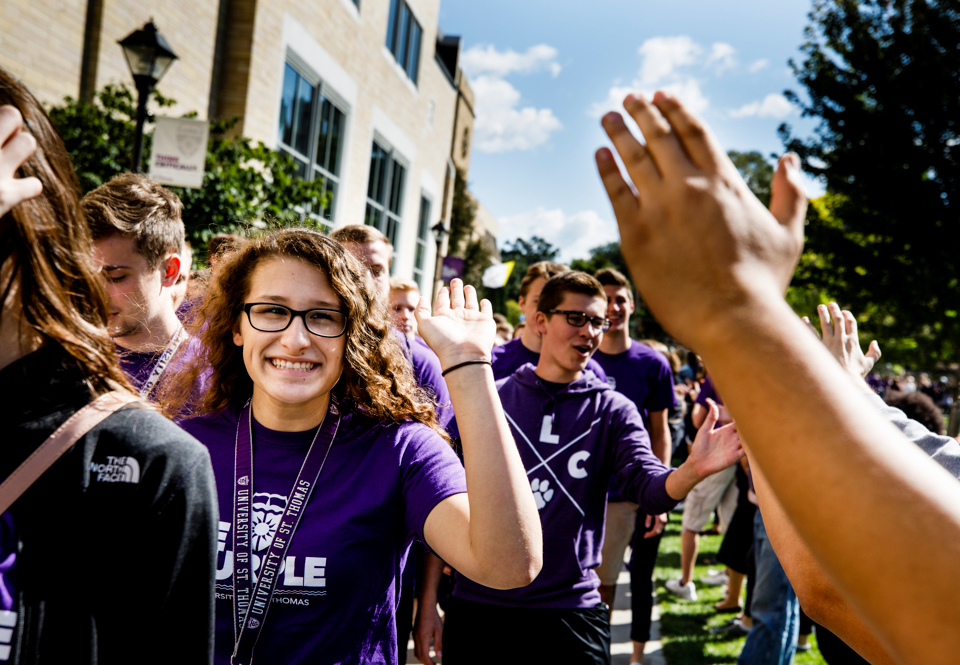 St. Thomas students high-five during March Through the Arches, an example of what makes Minnesota the happiest state.
