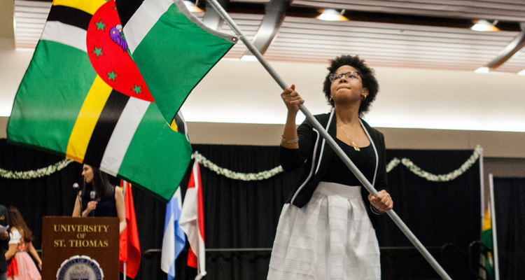 Chelsea Balthazar waves the flag of Dominica at the 28th Annual International Dinner in Woulfe Hall on April 1, 2017.