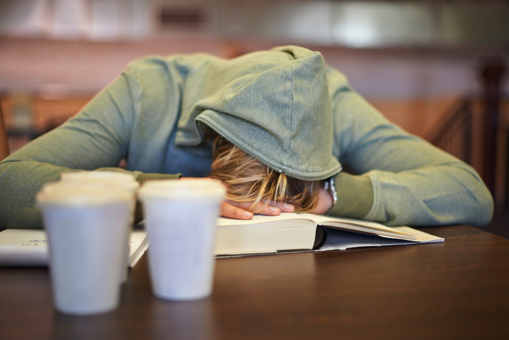 A student sleeps on the table while studying. The Center for College Sleep studies students' sleep and helps colleges and universities provide their students with better sleep.