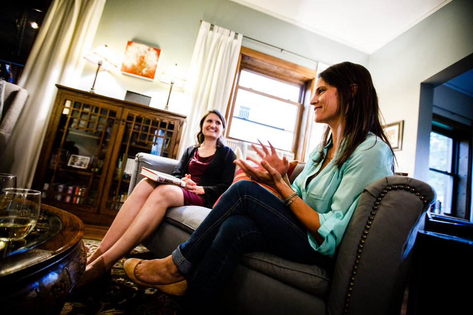 Anna Knier (left) and Annie Mossbrugger discuss a book during a "Well-Read Mom" book club meeting August 31, 2017 at the St. Paul home of Beth Nelson.