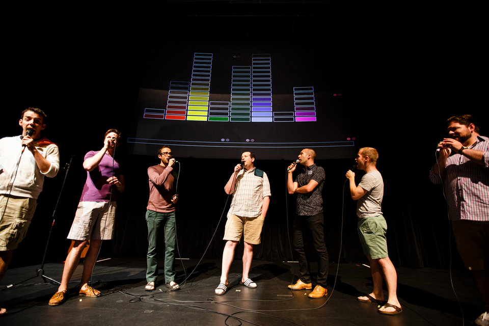 Member of Cantus perform with a projection in the background during a collaborative multimedia performance with the University of St. Thomas Playful Learning Lab and Twin Cities based sining group Cantus at the Science Museum of Minnesota in downtown St. Paul on July 8, 2016.
