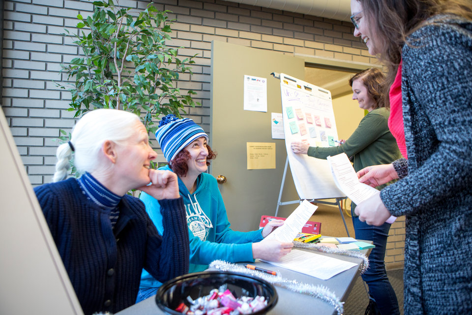 Lisa Kiesel (left) and Kate Lesch (blue hat) help guests get checked in during the mapping social justice event in Summit Classroom Building on Tuesday, November 21, 2017.