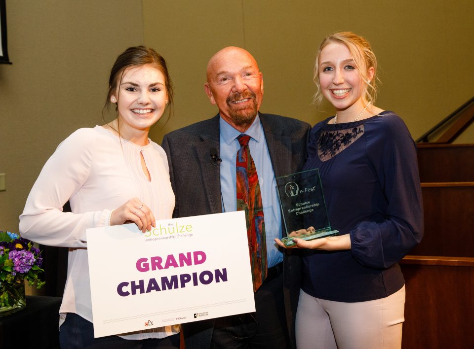 St. Thomas undergraduate students Jackie Page (left) and Megan Sharkus (right) stand with Richard Schulze on April 14 at e-Fest after being named grand champion for their business, ExpressionMed.