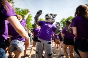 Tommie the mascot gives high fives to seniors during the 2018 March Through the Arches ceremony for graduating seniors on May 18, 2018 in St. Paul.