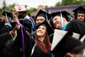 Students take a selfie during the 2018 Graduate Commencement ceremony in O'Shaughnessy Stadium on May 18, 2018 in St. Paul.