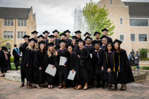 Student pose for a group photo on Monahan Plaza after the 2018 Graduate Commencement ceremony on May 18, 2018 in St. Paul.