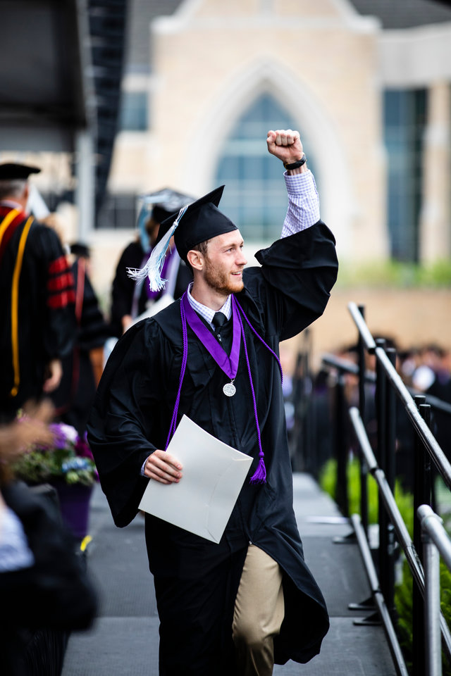 A graduating senior raises and arm in celebration after receiving his degree during the 2018 Undergraduate Commencement ceremony in O'Shaughnessy Stadium on May 18, 2018 in St. Paul.