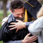 A graduating senior receives a hug from a family member during the 2018 Undergraduate Commencement ceremony in O'Shaughnessy Stadium on May 18, 2018 in St. Paul.