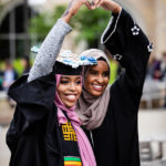 A graduating senior poses for a photo with a friend after the 2018 Undergraduate Commencement ceremony in O'Shaughnessy Stadium on May 18, 2018 in St. Paul.