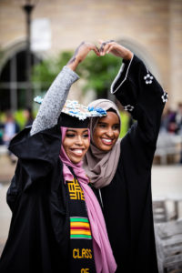 A graduating senior poses for a photo with a friend after the 2018 Undergraduate Commencement ceremony in O'Shaughnessy Stadium on May 18, 2018 in St. Paul.
