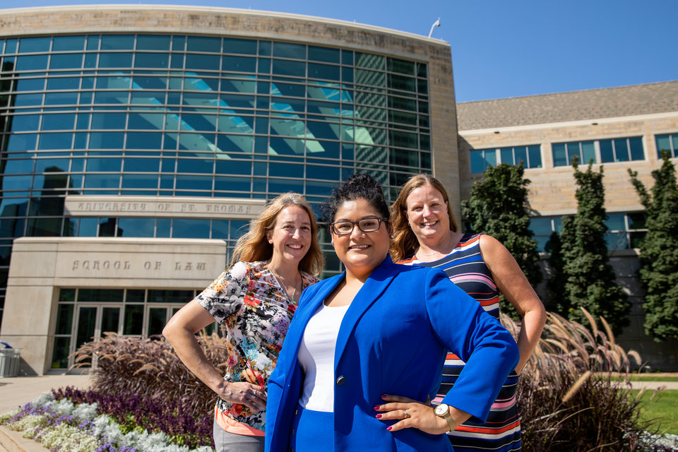 Left to right, Kathy Klos '07, third-year student Juana Cardenas and Sarah Kilibarda '04 pose for a portrait together outside of the University of St. Thomas School of Law in downtown Minneapolis on September 12, 2018.