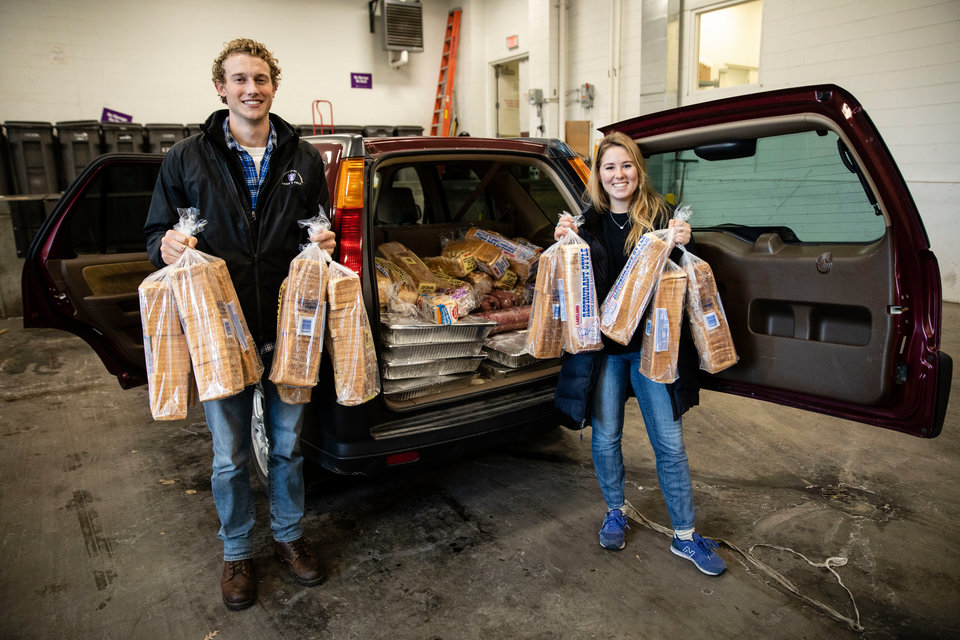 Hannah Wallace and Eric Udermann hold loafs of bread by Hannah's car on November 12, 2018 in the Anderson Student Center in St. Paul. Hannah Wallace collects leftover food from the View and brings it to a central receiving area as part of the Food Recovery Network.