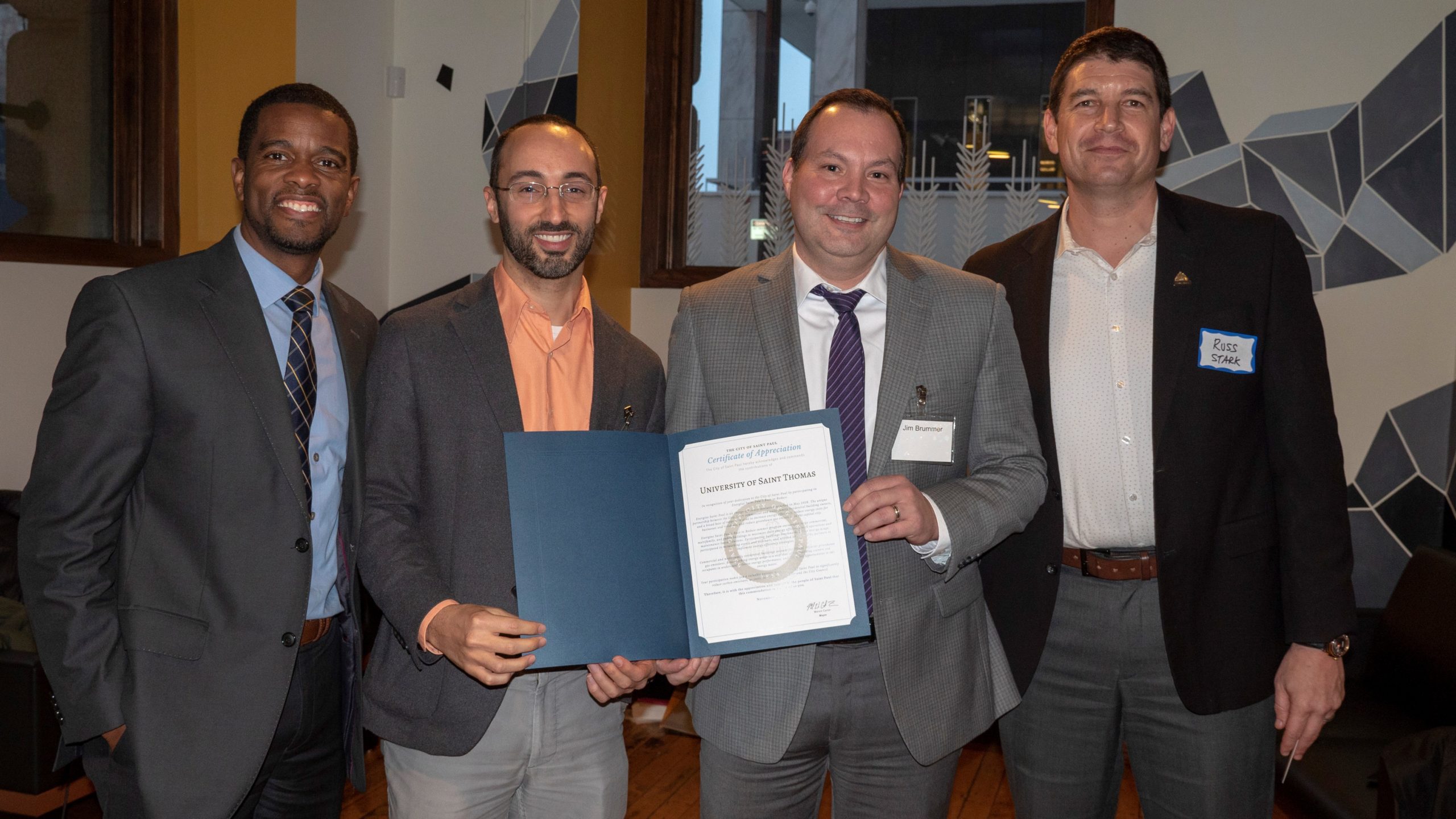 (l-r) St. Paul Mayor Melvin Carter, St. Thomas assistant director of sustainability Amir Nadav, associate vice president of facilities management Jim Brummer, and St. Paul's "Chief Resilience Officer" Russ Stark pose for a photo with St. Thomas' recognition in the city's Race to Reduce program.