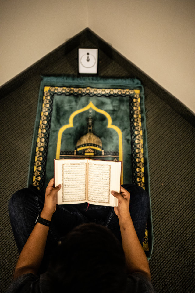 A student reads the Koran in the Muslim prayer space for men in Loras Hall on south campus in St. Paul.