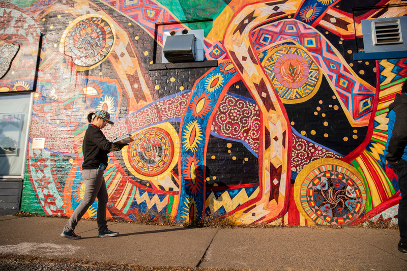 Students and faculty collaborate on a mapping and documentation project at a mural on Snelling Avenue in the Midway neighborhood in St. Paul on November 15, 2018. Here, Emma Rinn fills out survey information.