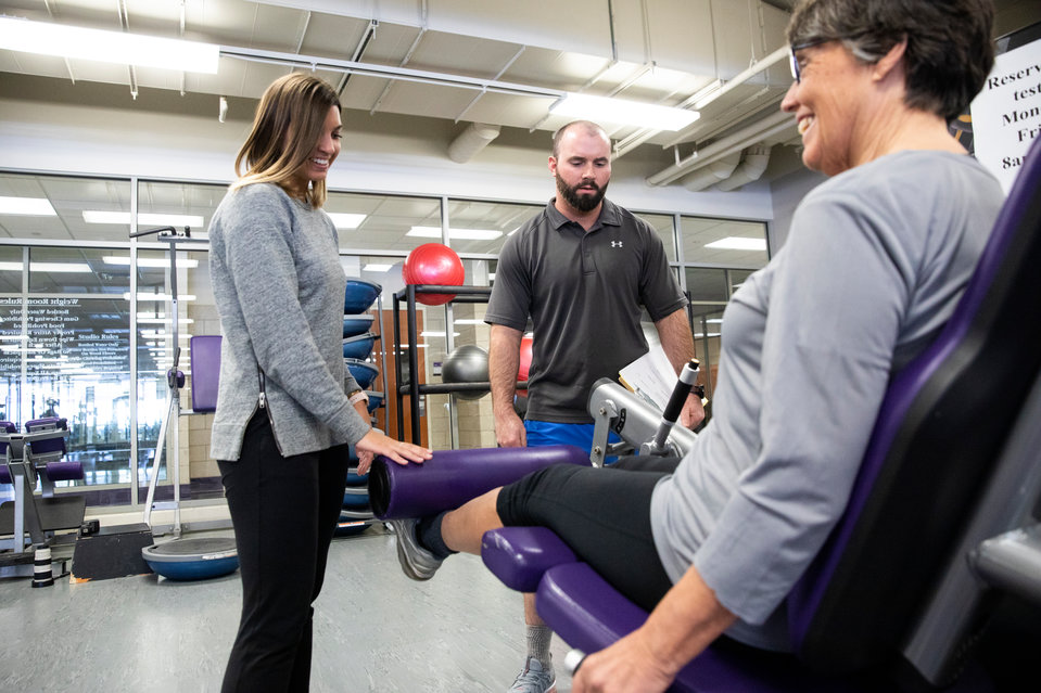 Student Mary Grace Knoll, left, and assistant professor J. Adam Korak, center, guide participant Ruthann Ryberg through an exercise in the Anderson Athletic Center on January 24, 2019, where senior volunteers participated in a variety of physical exercises, examining strength and balance as a part of the CAS SOLV Initiative's "Mindful Movement" research.