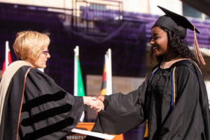 President Julie Sullivan hands a diploma to a graduate during the 2019 Graduate Commencement Ceremony in O’Shaughnessy Stadium on May 25, 2019 in St. Paul.