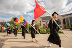 International students carry flags during the 2019 Graduate Commencement Ceremony in O’Shaughnessy Stadium on May 25, 2019 in St. Paul.