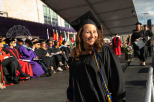 Melissa Palank, associate director of alumni events and operations, smiles after walking across the stage during the 2019 Graduate Commencement Ceremony in O’Shaughnessy Stadium on May 25, 2019 in St. Paul.
