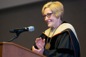 President Julie Sullivan applauds during the Dougherty Family College commencement.