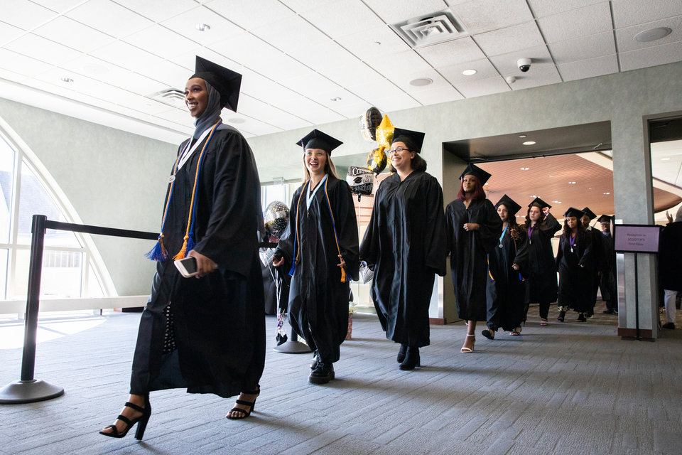 Dougherty Family College students walk through the Anderson Student Center into commencement. 