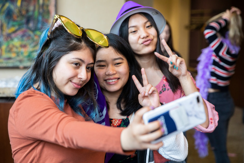 Students try on different props for the photo booth during the DFC Grad Fest in atrium of Schulze Hall on May 9, 2019.