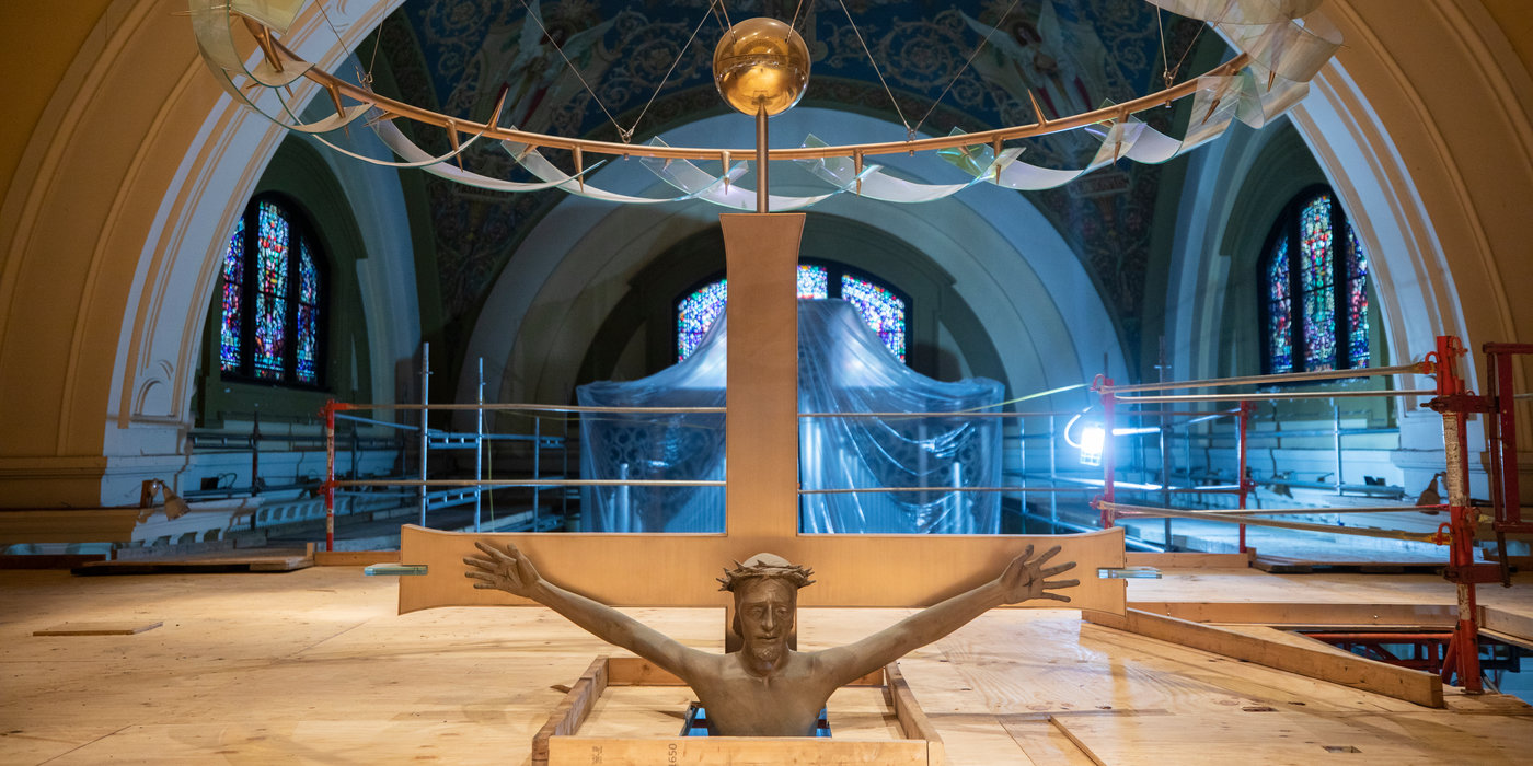 A large crucifix in the Chapel of St. Thomas Aquinas peaks through a layer of scaffolding.