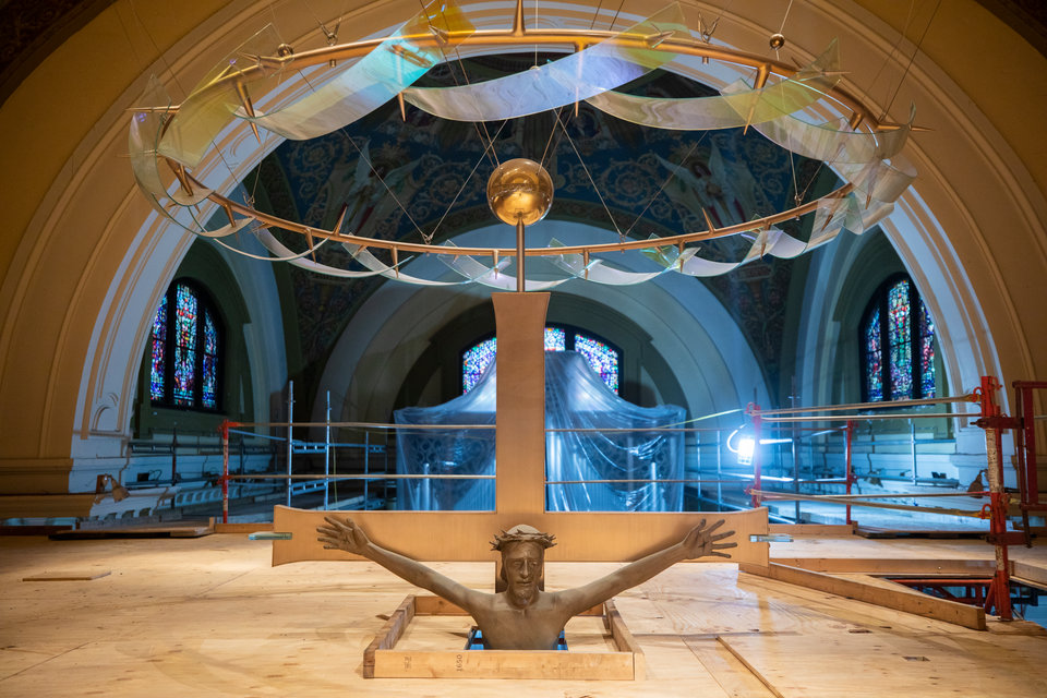 A large crucifix in the Chapel of St. Thomas Aquinas peaks through a layer of scaffolding.