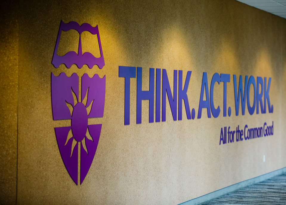 A sign reading "Think. Act. Work. All for the common good" is shown in the skyway between Schulze Hall and Terrence Murphy Hall October 11, 2017 in Minneapolis.