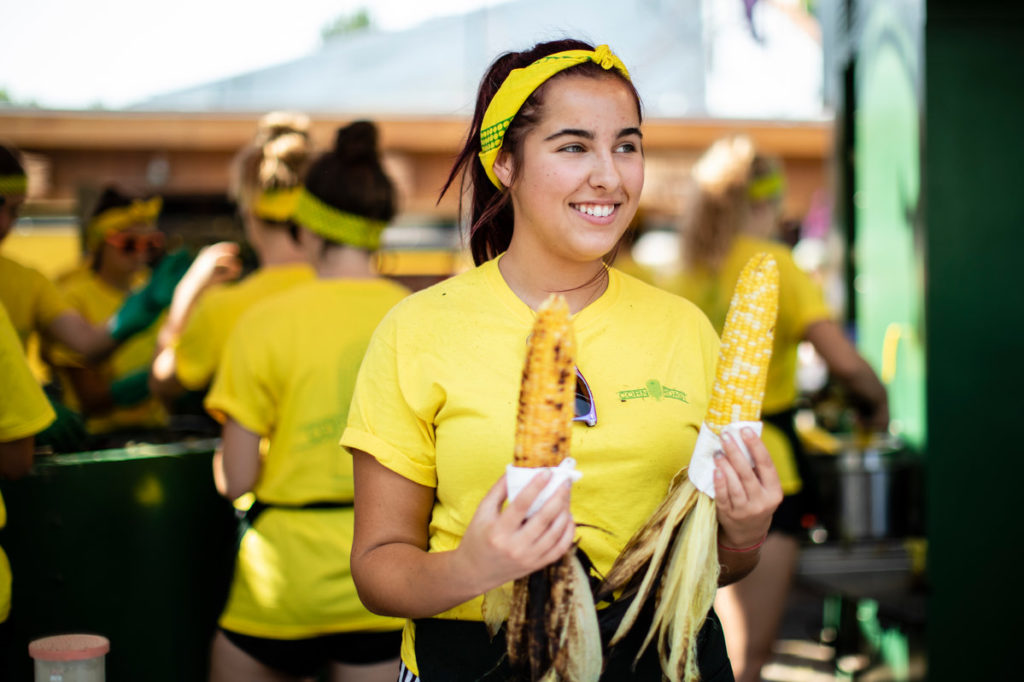 A worker holds corn for customers at the Corn Roast stand at the Minnesota State Fair.