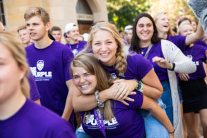 A student carries a friend on her back during the annual March through the Arches to celebrate the start of the school year and the arrival of a new class of freshmen on campus on September 3, 2019, in St. Paul.