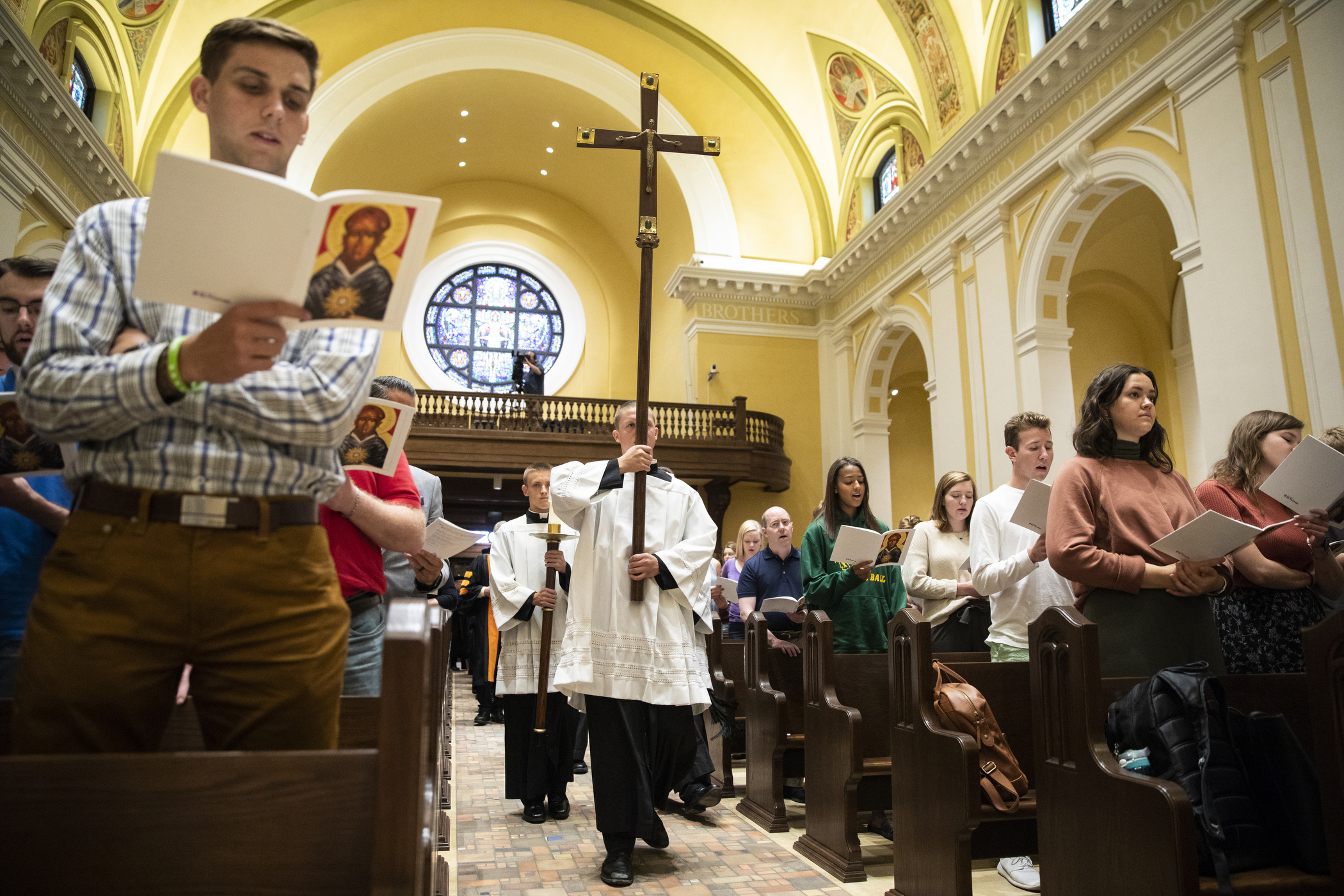 Students carry the cross during the Opening Mass Sept. 5, 2019 in the newly renovated interior of the Chapel of St. Thomas Aquinas.