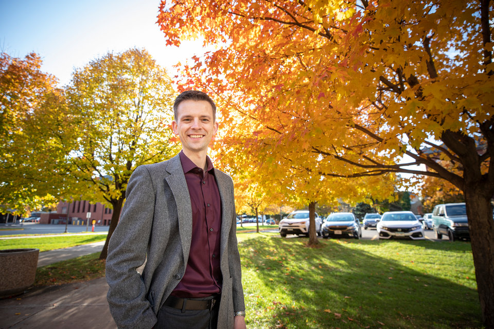 School of Engineering alum Matthew Deutsch poses for a portrait outside of the Frey Engineering and Science Center on a beautiful fall day with colorful leaves in the background.