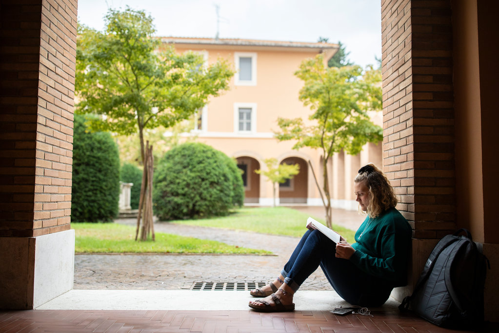 Student Madi Olson reads a book outside before Theology class at the Lay Centre in Rome, Italy on October 15, 2019.