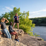 Students Sarah Benoy, Shukrani Nangwala and Mackenzie Stahl on the river bluffs overlooking the Mississippi River. Mark Brown/University of St. Thomas