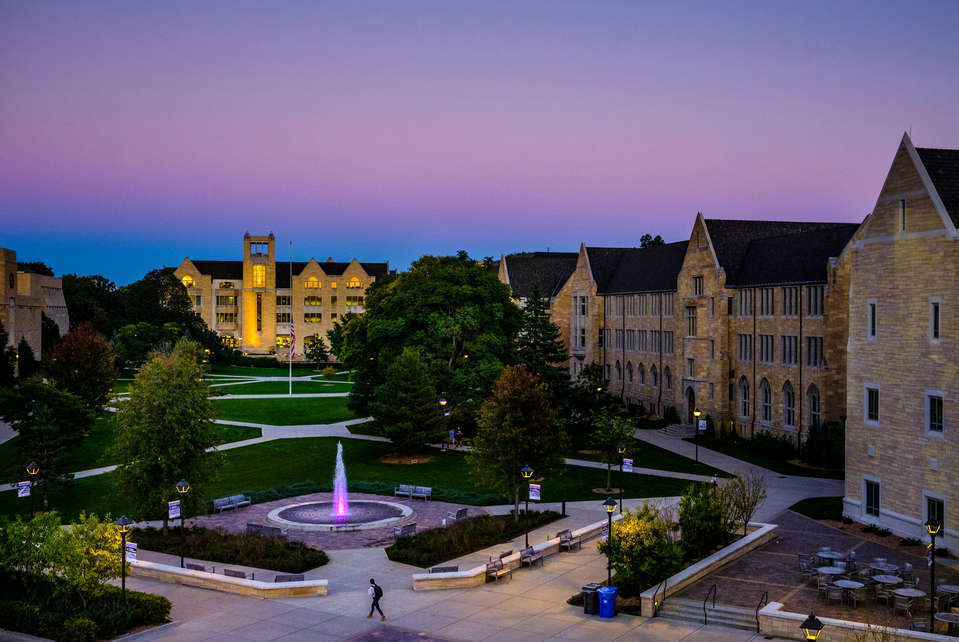 The lower quad is seen against a purple and blue sky at sunset September 29, 2016. O'Shaughnessy-Frey Library is at left and the Harpole fountain is in the foreground.