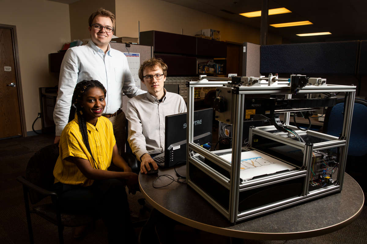 Engineering students Meheret Tadesse, Henry Martinson and Charles Lundquist pose with the “Tactile Diagram Scanner” technology they developed. Liam James Doyle/University of St. Thomas