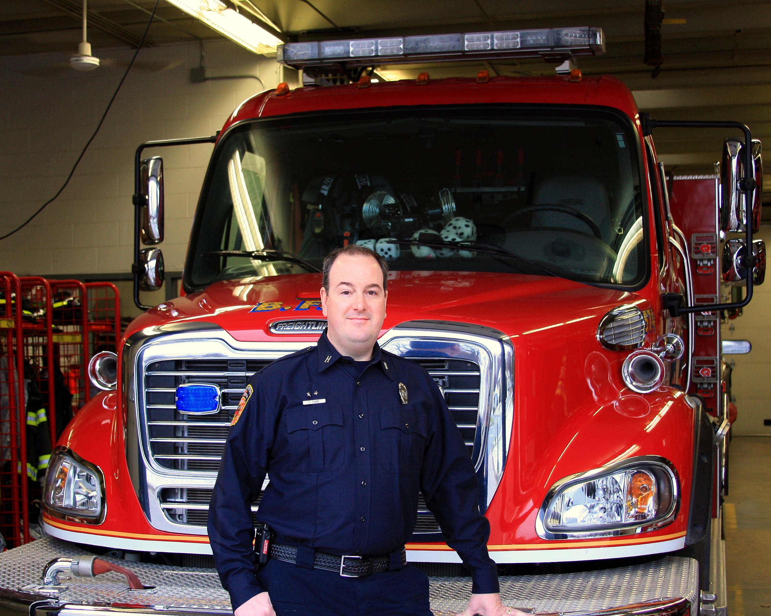 Chad Ford stands in front of engine #4 at Bloomington Fire House #4.