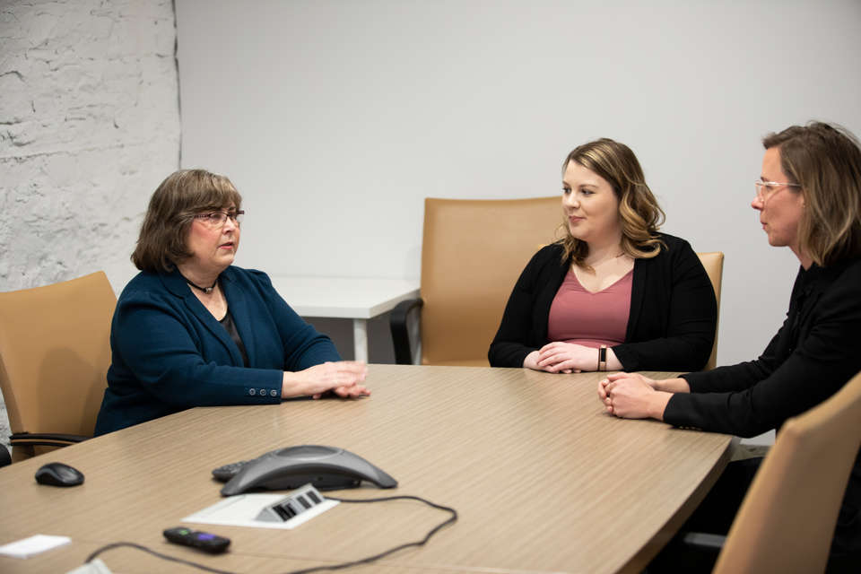 Executive Director Jean Lastine, Emily Ginsburg ’18, and Jessica Melheim ’15, talk in a conference room at the Cetnral Minnesota Legal Services office in Minneapolis on February 28, 2020. Central Minnesota Legal Services has used the talents of the School of Law’s Archbishop Ireland Justice Fellows to help outstate residents resolve legal issues.