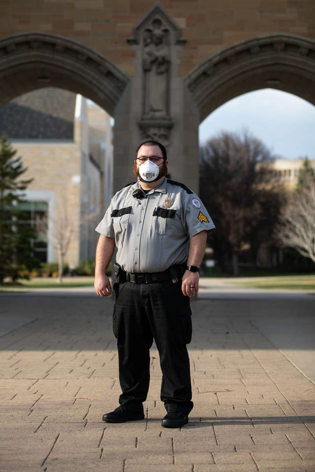 Patrol Sergeant Tyler Vogel poses for a portrait in front the the Arches on the St. Paul campus on April 18, 2020. Vogel is one of the critical employees ensuring that students and staff remaining on campus are looked after.