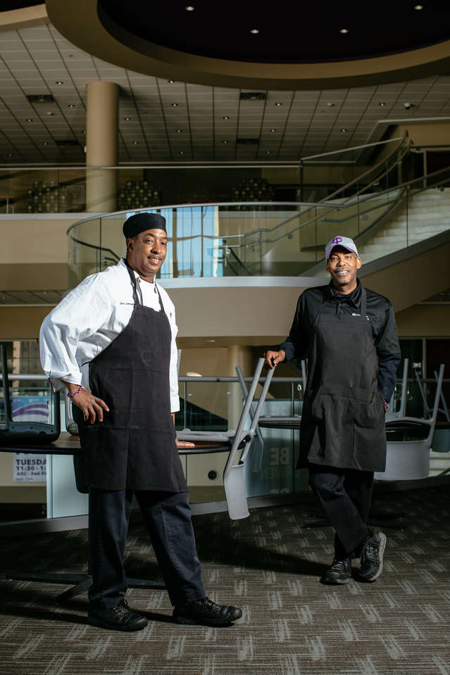 Dining services staffers Carl Littlejohn, left, and brother Anthony Littlejohn, right, pose for a photo in the Anderson Student Center. They are part of a team of critical employees ensuring that students and staff remaining on campus are looked after.