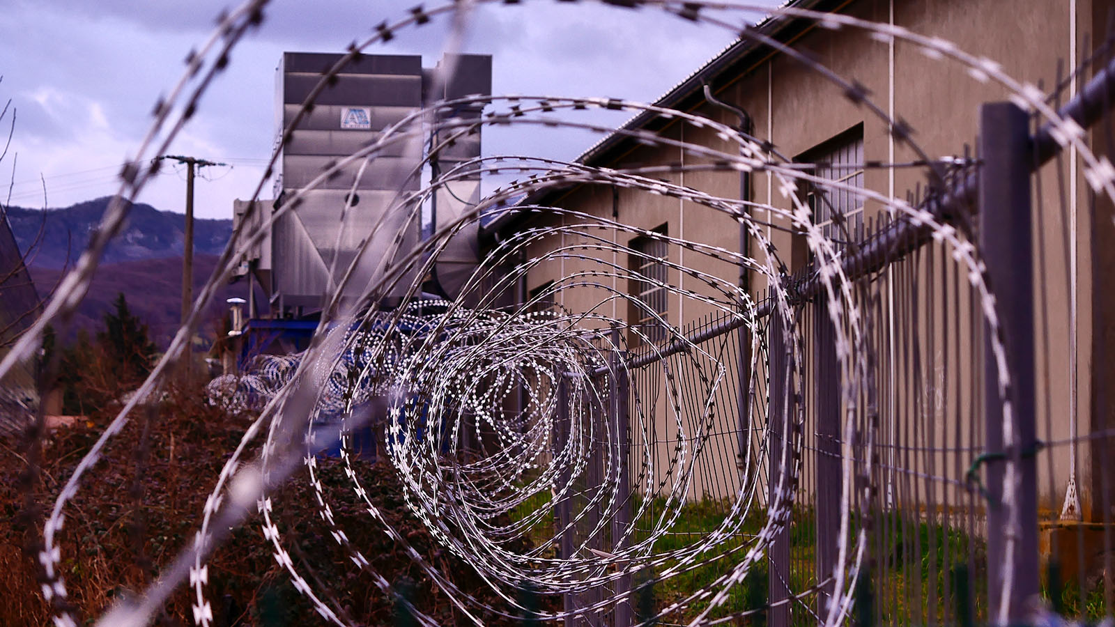 A view of barbed wire in front of a prison