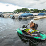 Schulze Innovation Scholar Dylan Dierking founded Foodski, a jet ski food delivery business based in White Bear Lake. Dierking takes orders for deliveries from customers ordering food from area restaurants and delivers them to homes and boats around the lake on his jet ski. Photos taken on July 22, 2020, in White Bear Lake. Dylan Dierking takes a delivery to a dock in a marina for delivery via jet ski.
