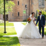 A couple getting married on campus walks across the quad. Mark Brown/University of St. Thomas