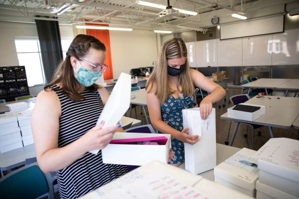 Mechanical Engineering majors Elise Rodich, left, and MiKyla Harjamaki, right, assemble boxes for the Playful Learning Lab's PLAYground virtual learning program. Mark Brown/University of St. Thomas