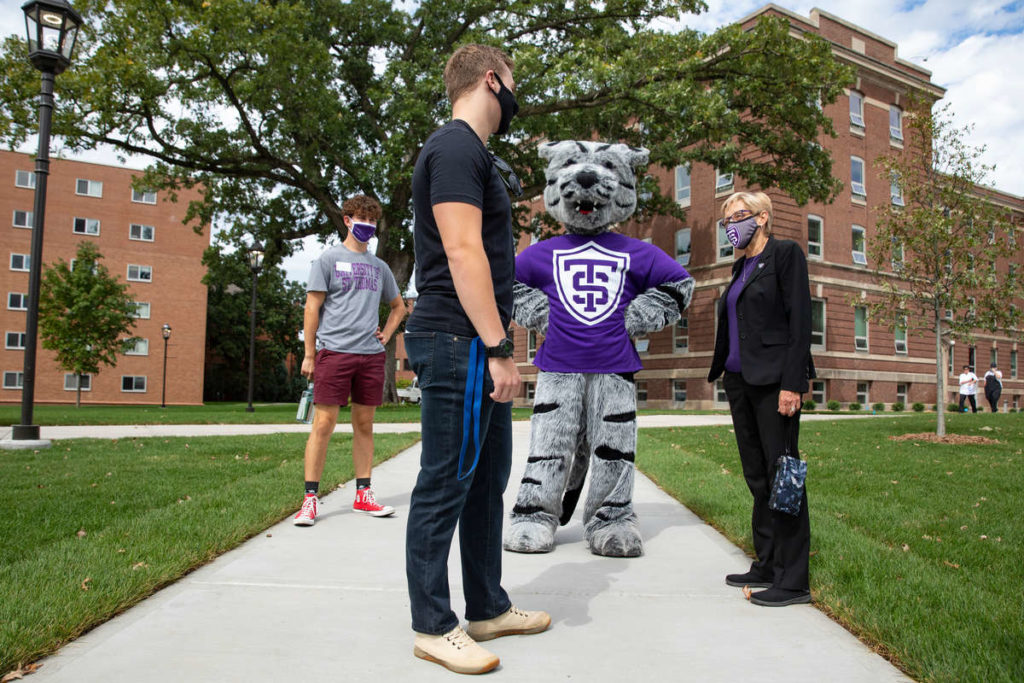 President Julie Sullivan and Tommie talk with a student during Labor Day weekend.