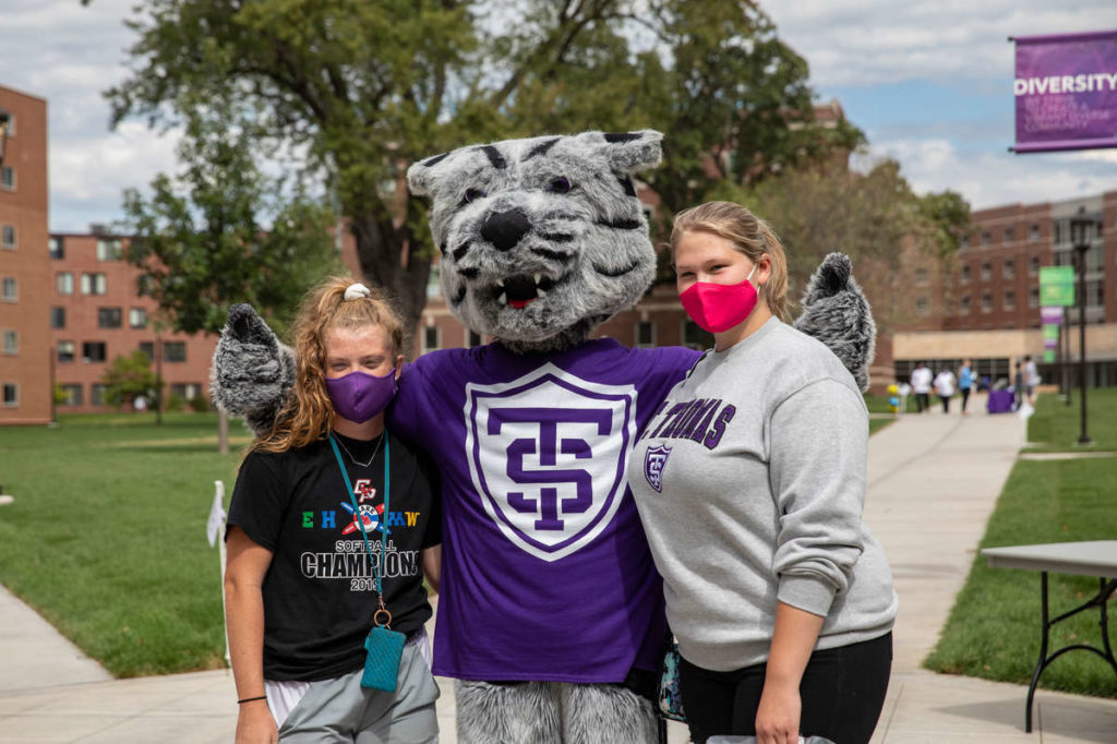 Tommie poses with students on the upper quad.