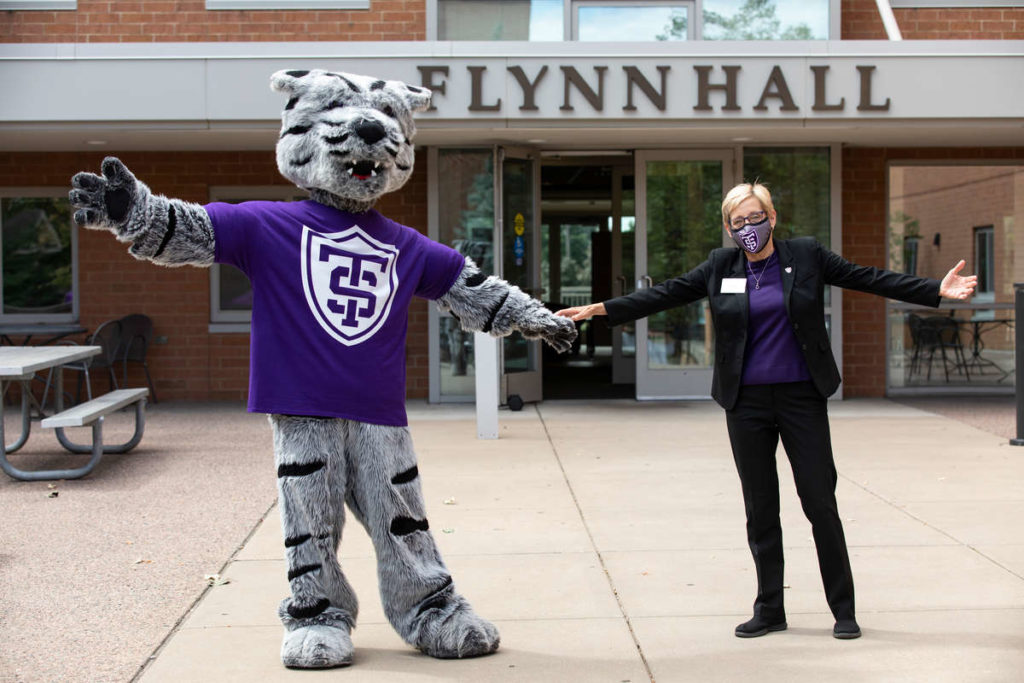 President Julie Sullivan poses for a photo with Tommie in front of Flynn Hall on Labor Day weekend.