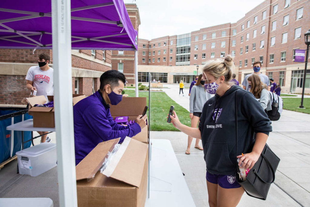 Thuy Nguyen, a graduate assistant with Campus Life, scans a student's cell phone while handing out care packets.