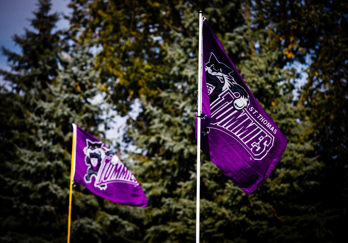 Purple flags reading "St. Thomas Tommies" flap in the wind as fans tailgate on south campus before the Tommie Johnnie football game September 27, 2014.